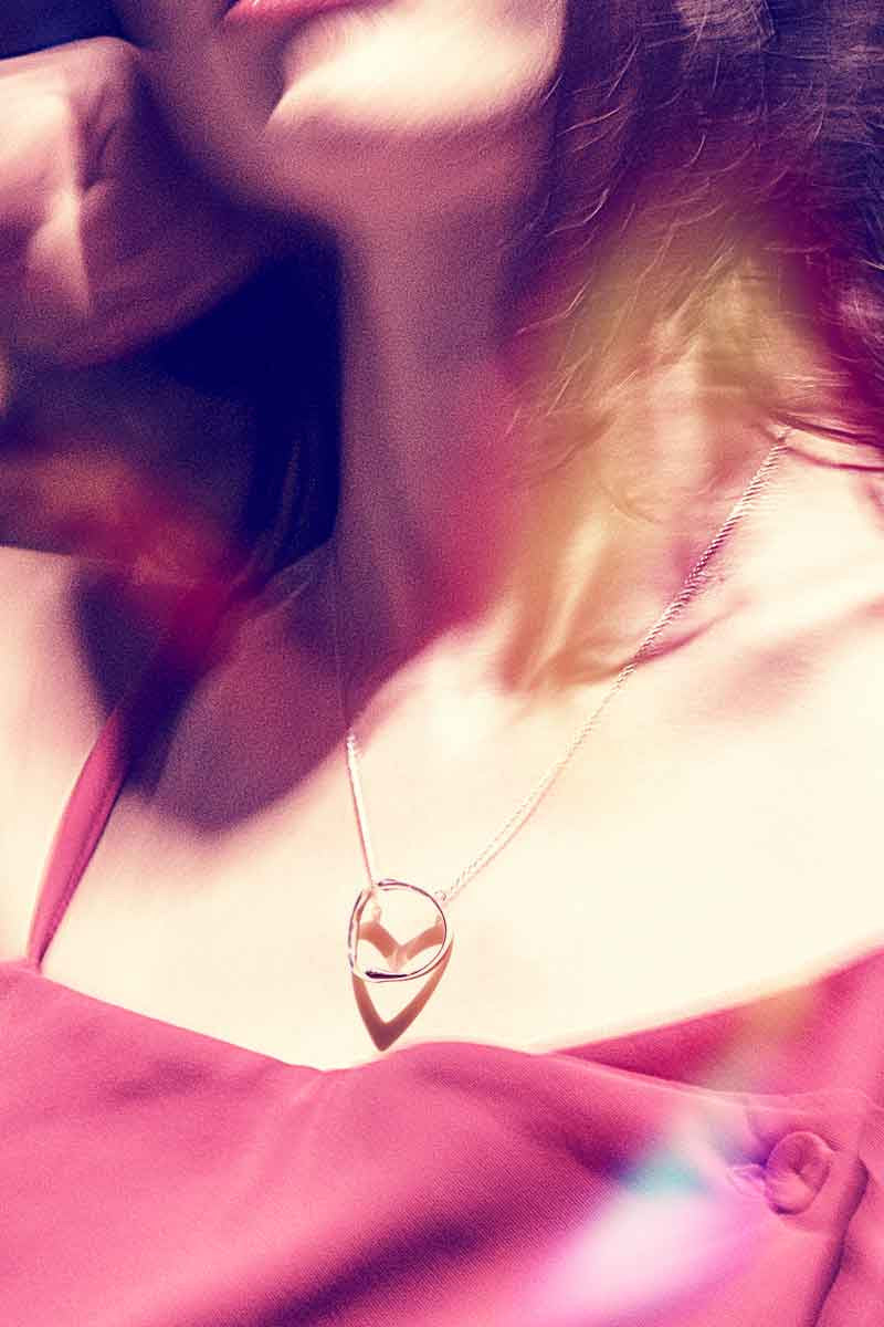 Shadow heart necklace shows its heart shadow on a model